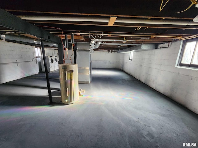 basement featuring washing machine and clothes dryer and electric water heater