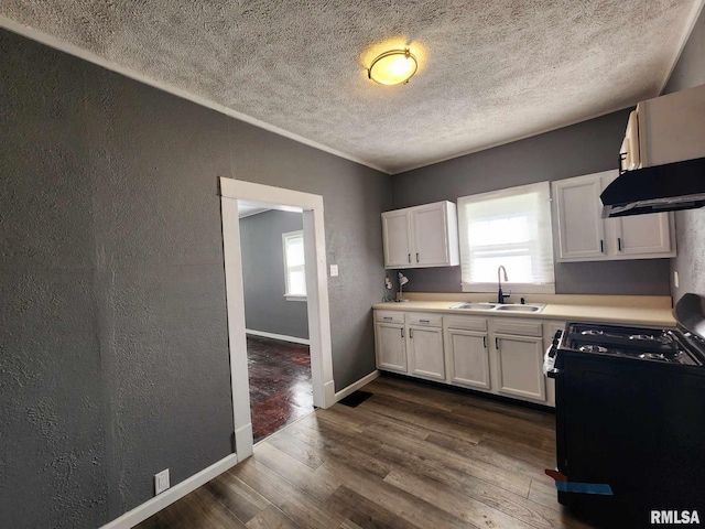 kitchen with dark wood-type flooring, white cabinets, black stove, sink, and a textured ceiling