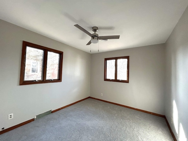 carpeted spare room featuring ceiling fan