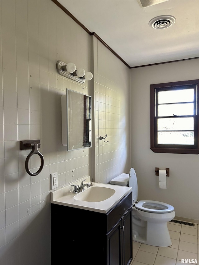 bathroom with vanity, tile patterned floors, tile walls, and toilet