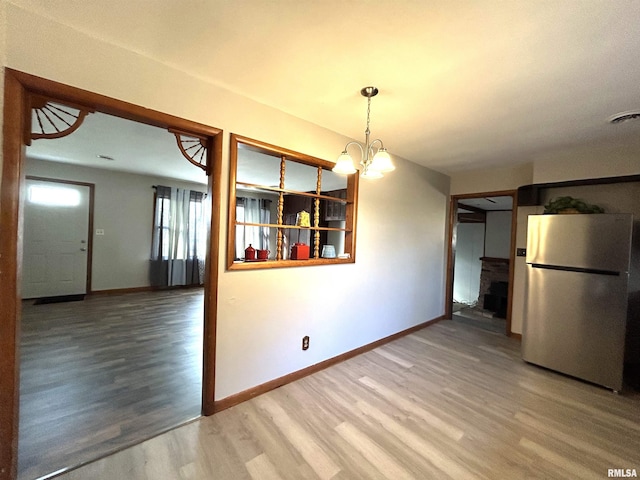 unfurnished dining area featuring hardwood / wood-style floors and a chandelier