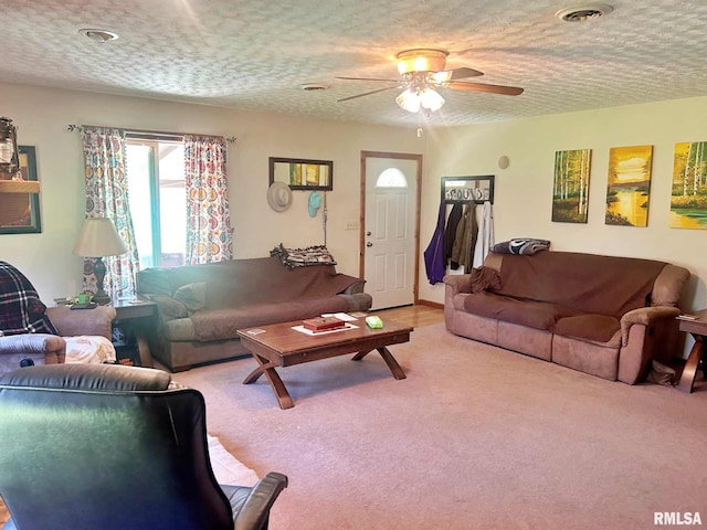 living room with a textured ceiling, ceiling fan, and light carpet