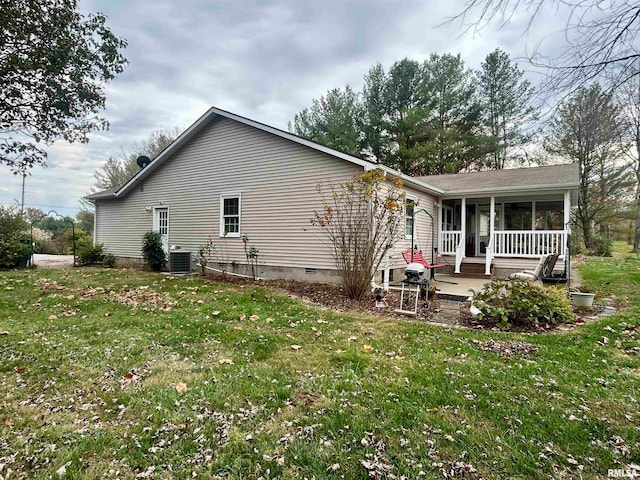 rear view of house featuring a lawn and central AC