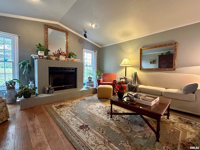 living room with a fireplace, wood-type flooring, lofted ceiling, and ornamental molding