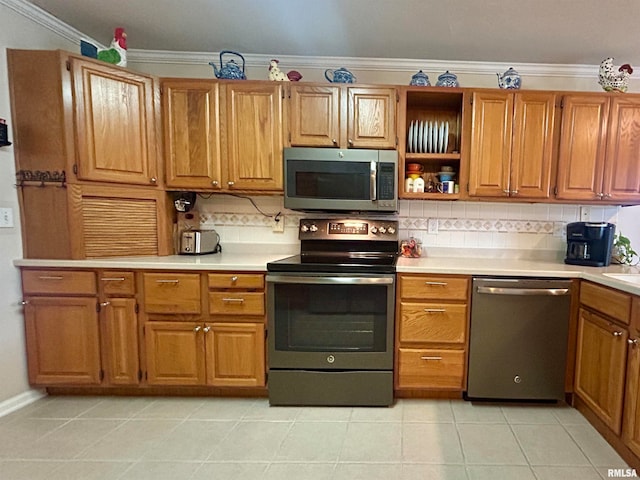 kitchen with backsplash, light tile patterned flooring, ornamental molding, and stainless steel appliances