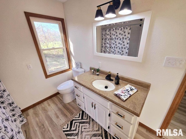 bathroom with hardwood / wood-style flooring, vanity, toilet, and walk in shower