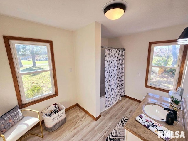 bathroom with shower / bathtub combination with curtain, vanity, and wood-type flooring