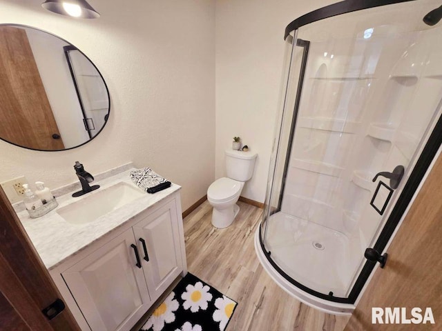 bathroom featuring hardwood / wood-style floors, vanity, an enclosed shower, and toilet