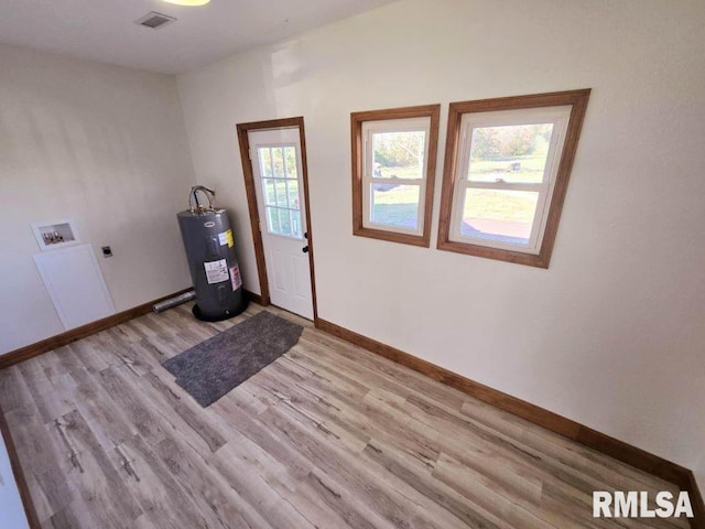 washroom featuring washer hookup, electric dryer hookup, light wood-type flooring, and electric water heater