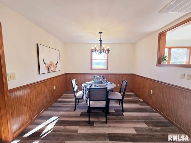 dining area featuring dark hardwood / wood-style flooring and a chandelier