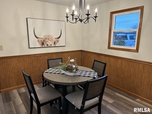 dining space with dark wood-type flooring and a notable chandelier