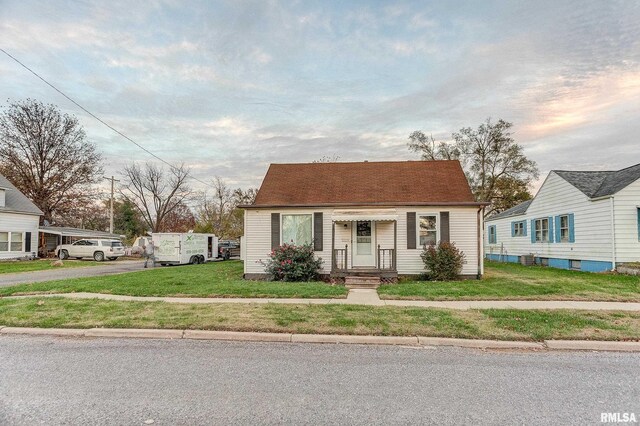 bungalow-style home with a front yard