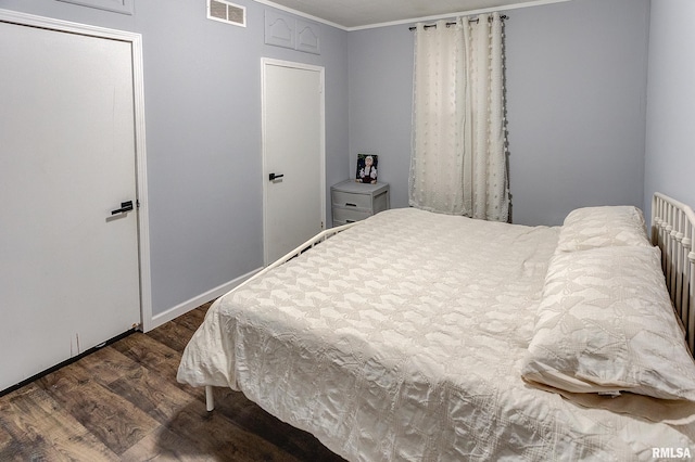 bedroom featuring dark wood-type flooring and ornamental molding