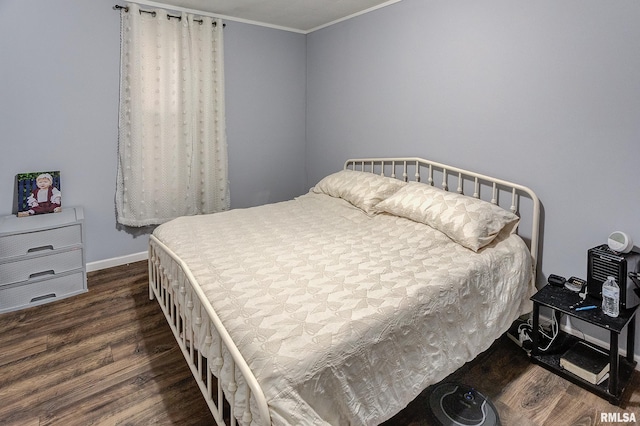 bedroom with crown molding and dark wood-type flooring