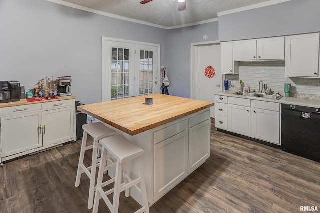 kitchen with white cabinets, dark hardwood / wood-style floors, black dishwasher, and wooden counters