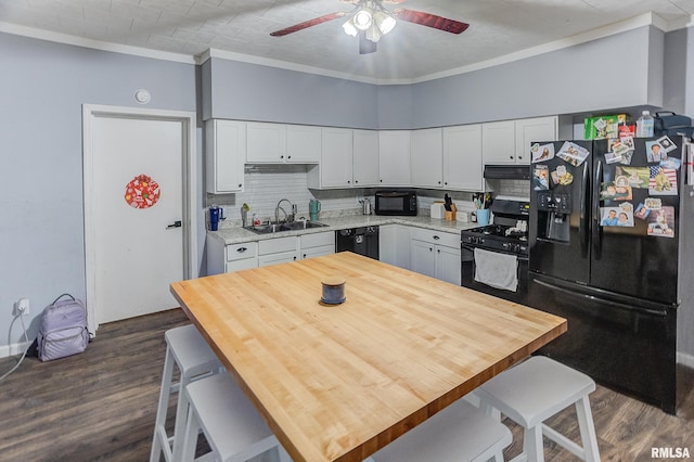 kitchen with crown molding, sink, white cabinets, and black appliances