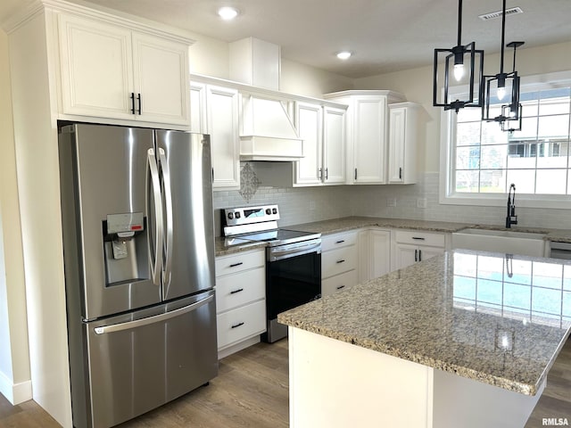 kitchen featuring custom range hood, stainless steel appliances, white cabinetry, and sink