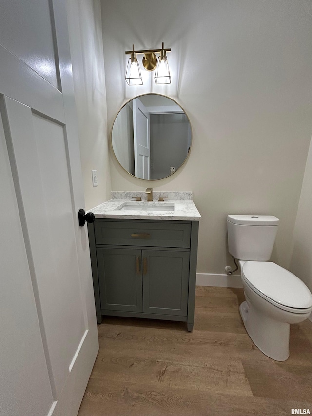 bathroom with toilet, vanity, and hardwood / wood-style flooring