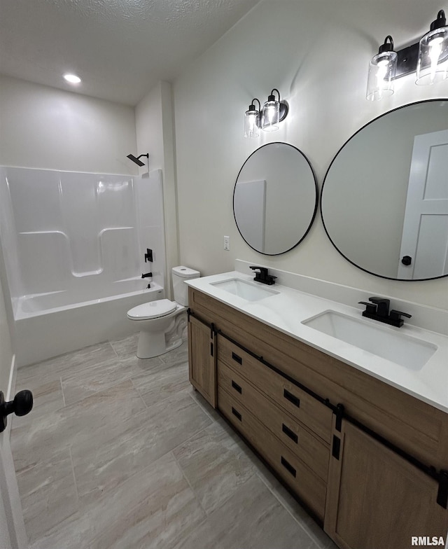 full bathroom with toilet, vanity, a textured ceiling, and tub / shower combination