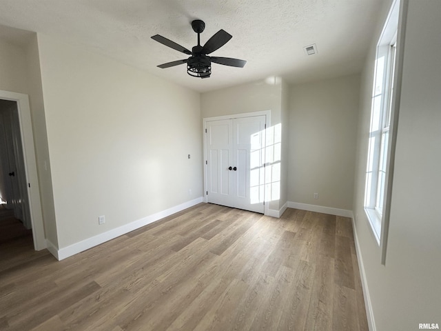 entrance foyer with ceiling fan, a textured ceiling, and light wood-type flooring