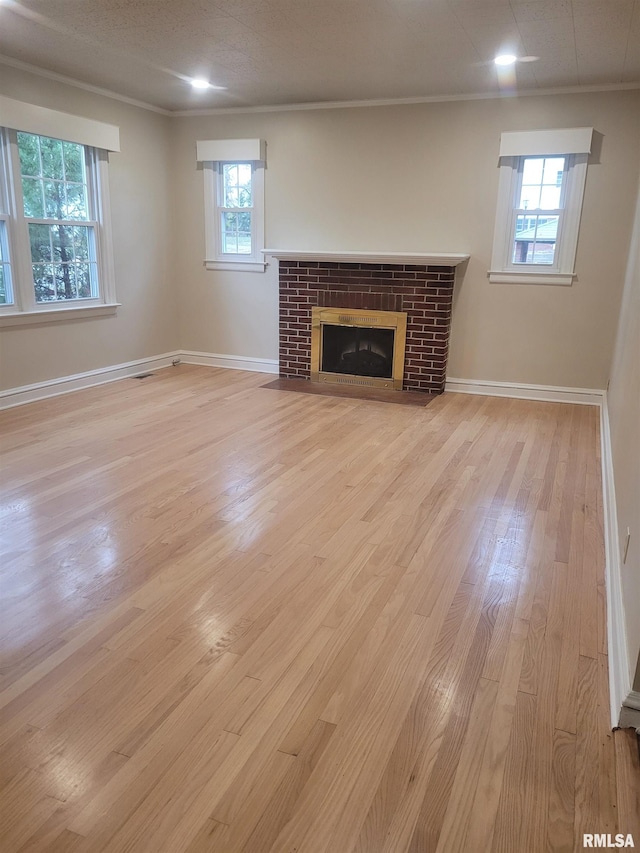 unfurnished living room with a textured ceiling, ornamental molding, a fireplace, and light hardwood / wood-style flooring