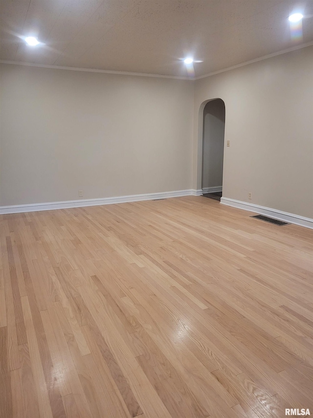 unfurnished room featuring light wood-type flooring and ornamental molding