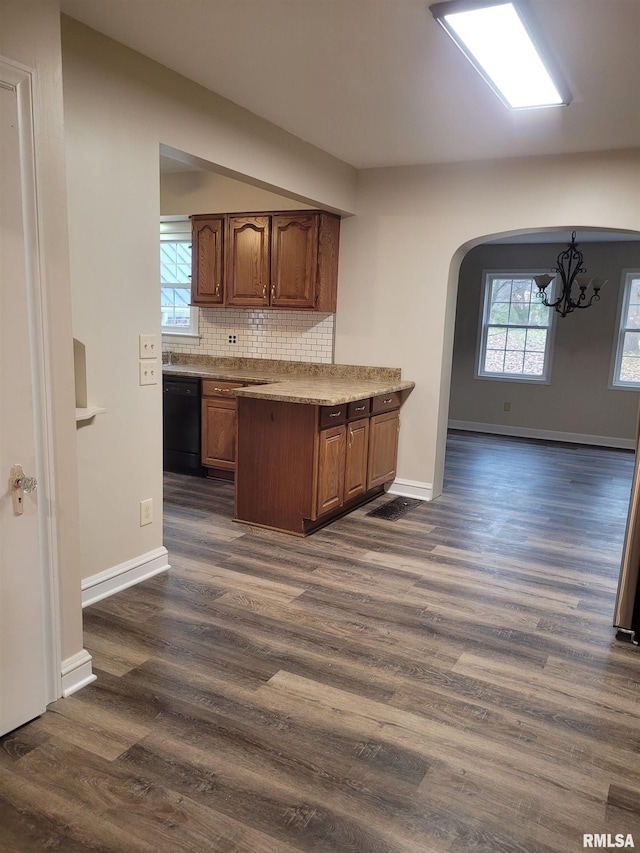 kitchen with decorative light fixtures, black dishwasher, dark hardwood / wood-style floors, and a notable chandelier