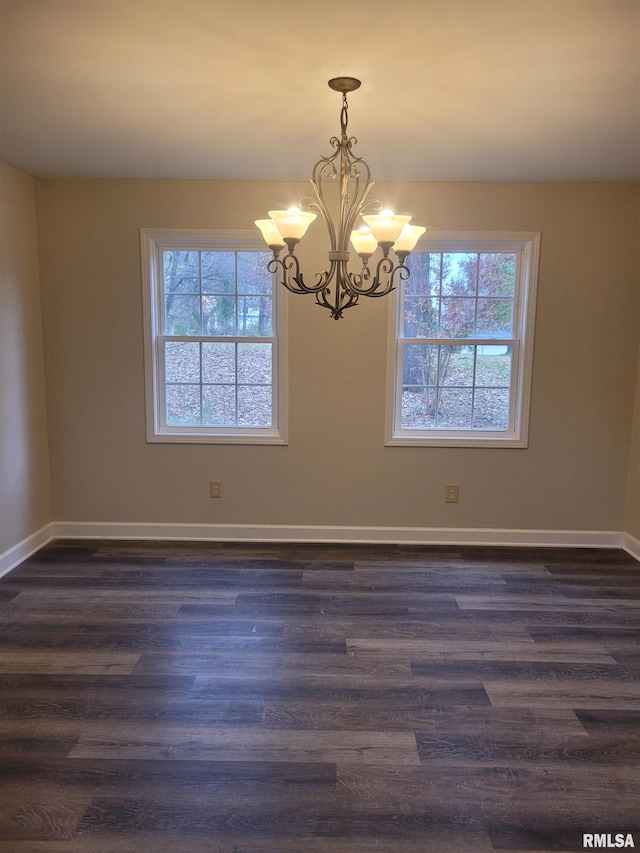 unfurnished room featuring dark hardwood / wood-style flooring and a notable chandelier