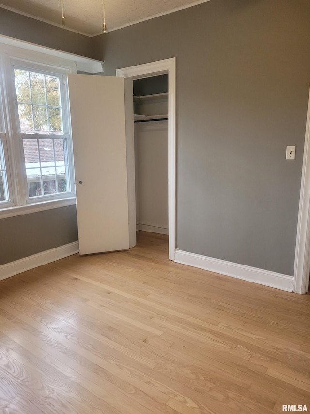 unfurnished bedroom with light hardwood / wood-style flooring and a closet