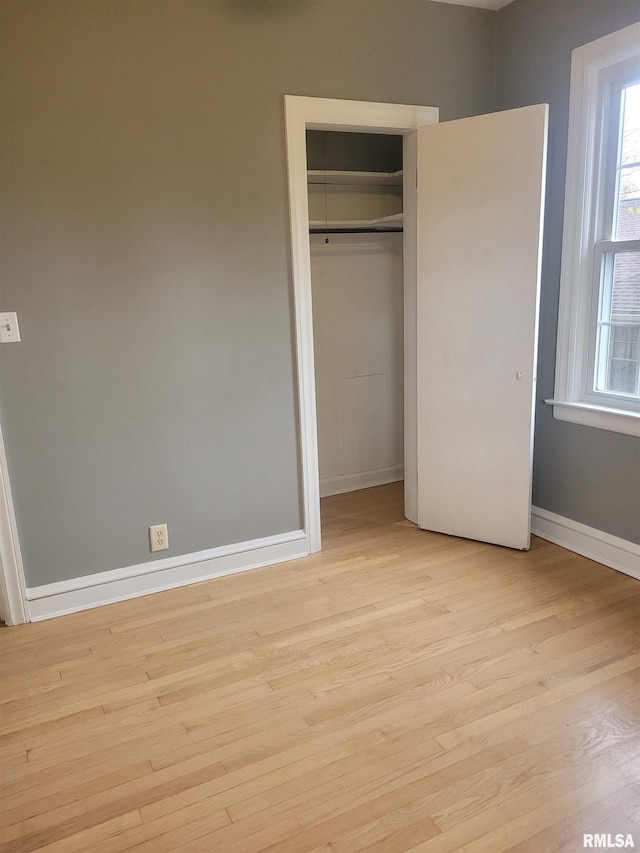 unfurnished bedroom with light hardwood / wood-style floors and a closet