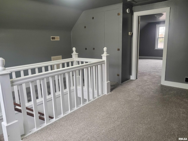 corridor with carpet flooring and lofted ceiling