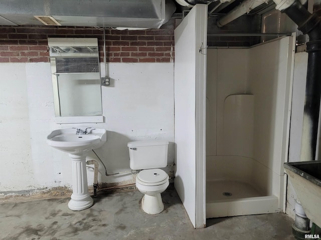 bathroom with toilet, concrete floors, and walk in shower