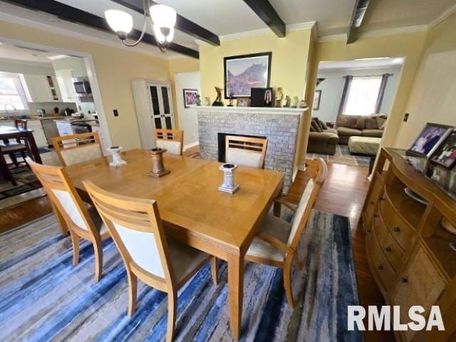 dining room with a wealth of natural light, dark wood-type flooring, and a notable chandelier