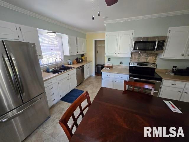 kitchen with crown molding, sink, white cabinetry, and stainless steel appliances