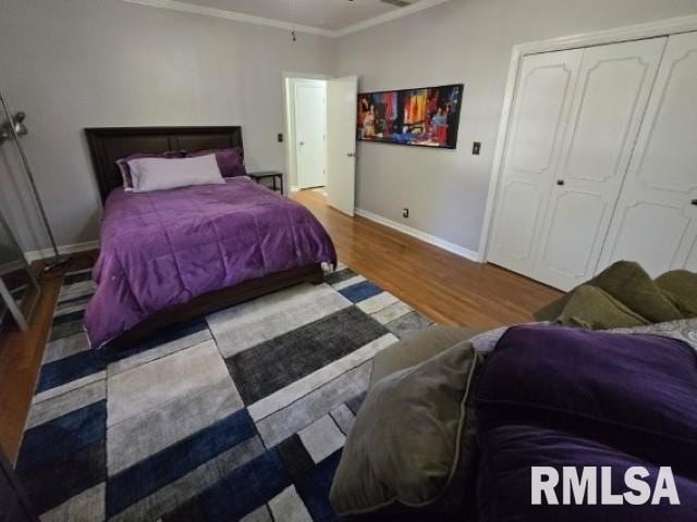 bedroom with hardwood / wood-style floors, a closet, and crown molding