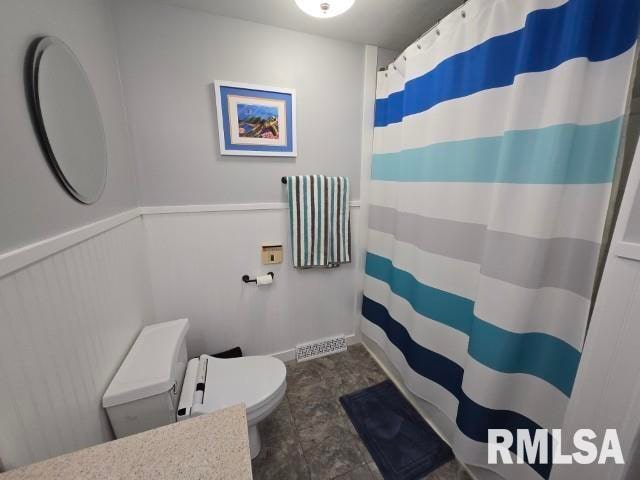 bathroom featuring a shower with curtain and toilet