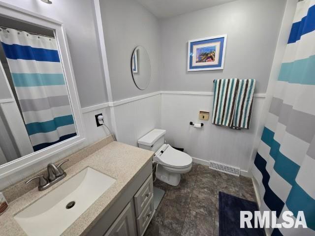 bathroom featuring walk in shower, vanity, and toilet