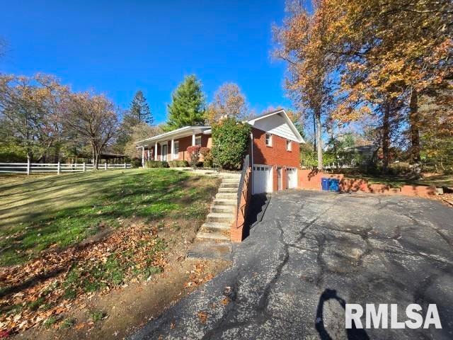 view of front facade featuring a front yard, a porch, and a garage