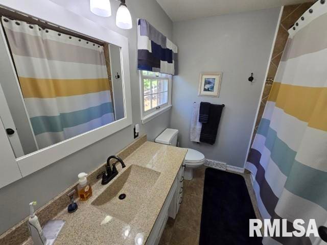 bathroom featuring tile patterned flooring, vanity, and toilet