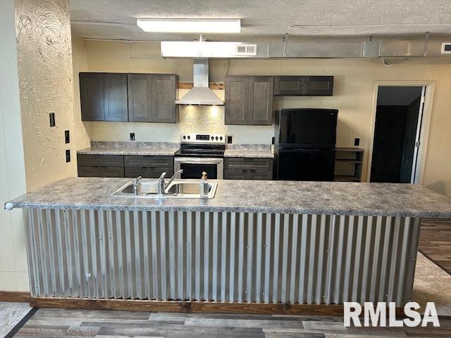 102 W 3rd St, Ina, IL 62846 - kitchen with wall chimney exhaust hood, electric stove, freestanding refrigerator, wood finished floors, and a peninsula
