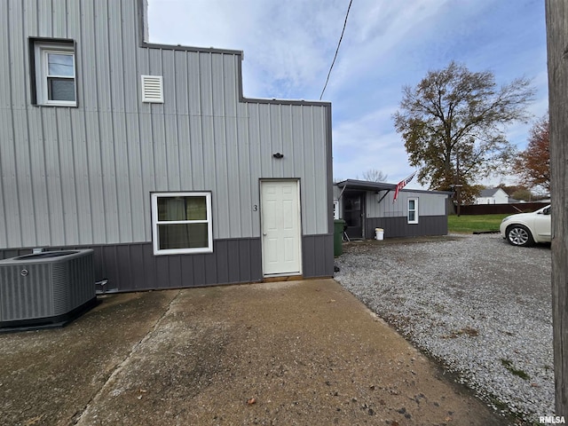 102 W 3rd St, Ina, IL 62846 - view of home's exterior with a central AC unit and board and batten siding