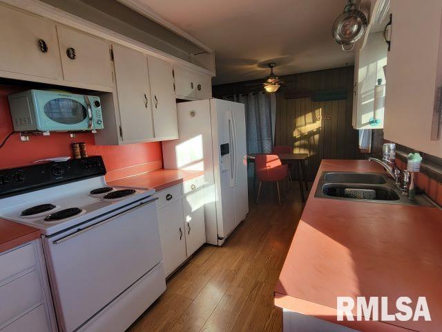 kitchen featuring white cabinetry, sink, ceiling fan, light hardwood / wood-style floors, and white appliances