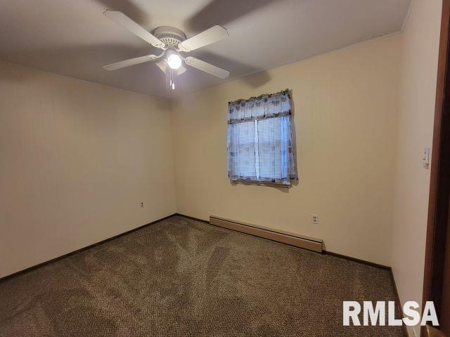 carpeted empty room with a baseboard heating unit and ceiling fan