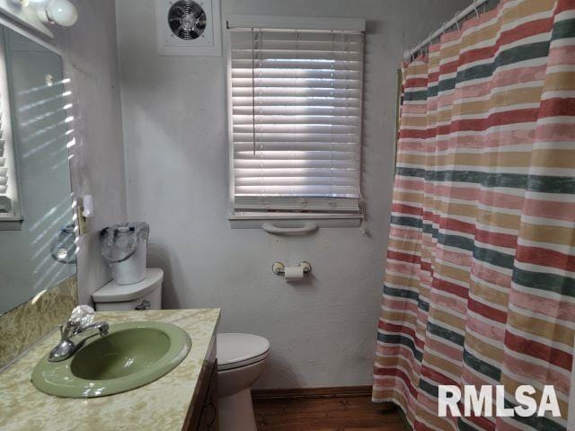 bathroom featuring hardwood / wood-style floors, vanity, toilet, and walk in shower