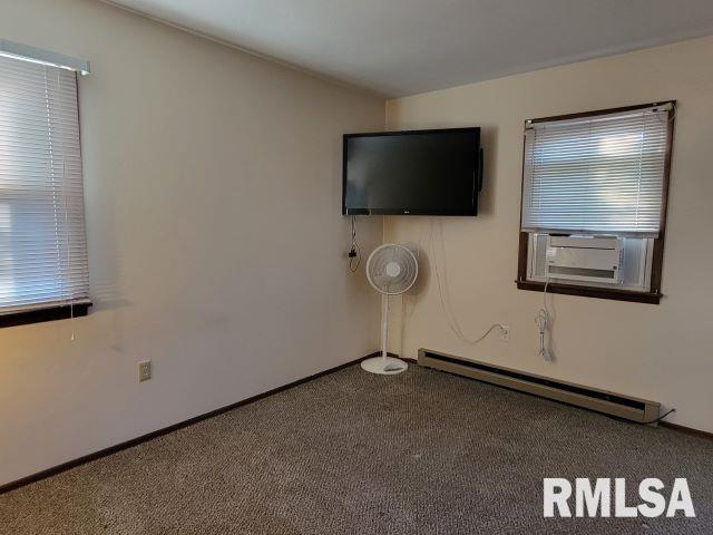 interior space featuring carpet, baseboards, cooling unit, and baseboard heating