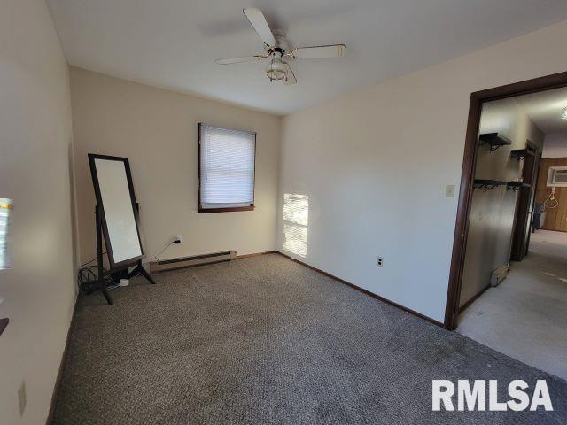 empty room featuring baseboard heating, carpet, a ceiling fan, and baseboards