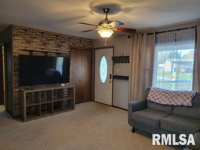 living room with a ceiling fan and light carpet