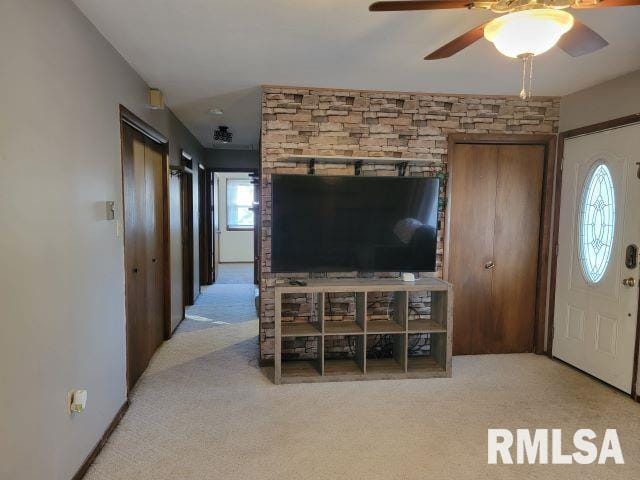 carpeted living room with a wealth of natural light and ceiling fan