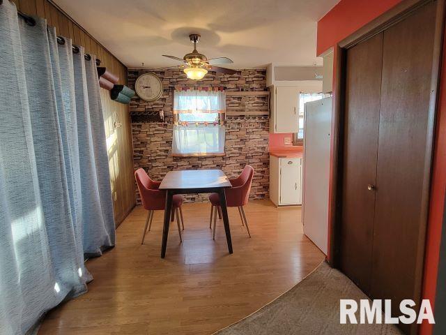 dining space with a ceiling fan and light wood-style flooring