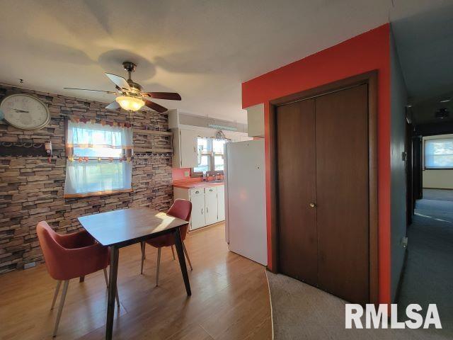 dining area featuring light wood finished floors and a ceiling fan